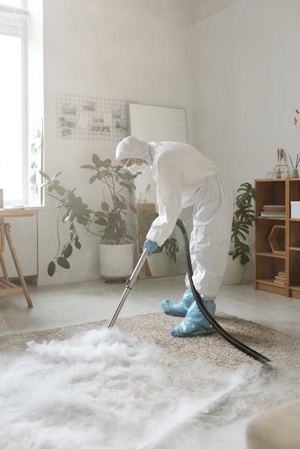 A person kneeling on a patterned carpet in a residential room, preparing a yellow portable vacuum cleaner for surface cleaning. The individual is wearing a beige shirt and blue jeans, and is opening the vacuum's lid to access its filter and storage compartment. The room features a wooden floor and soft lighting, highlighting the cleanliness of the carpet and nearby surfaces. This scene illustrates domestic cleaning activities, emphasizing thorough surface maintenance and hygiene, consistent with the services offered by Bayswater Cleaners as described on their website for affordable carpet cleaning on Porchester Road, Bayswater.